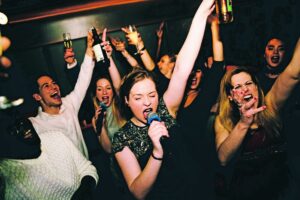 Groupe d'amies entrain de chanter dans une karaoké Box